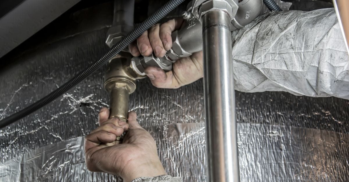 Licensed plumber completing a hot water unit installation